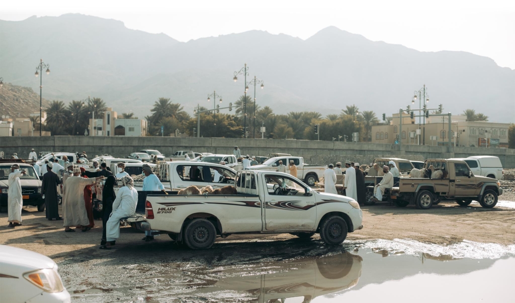 Pohled na improvizovaný kozí trh na zabláceném parkovišti během covidové pandemie v Ománském městě Nizwa.