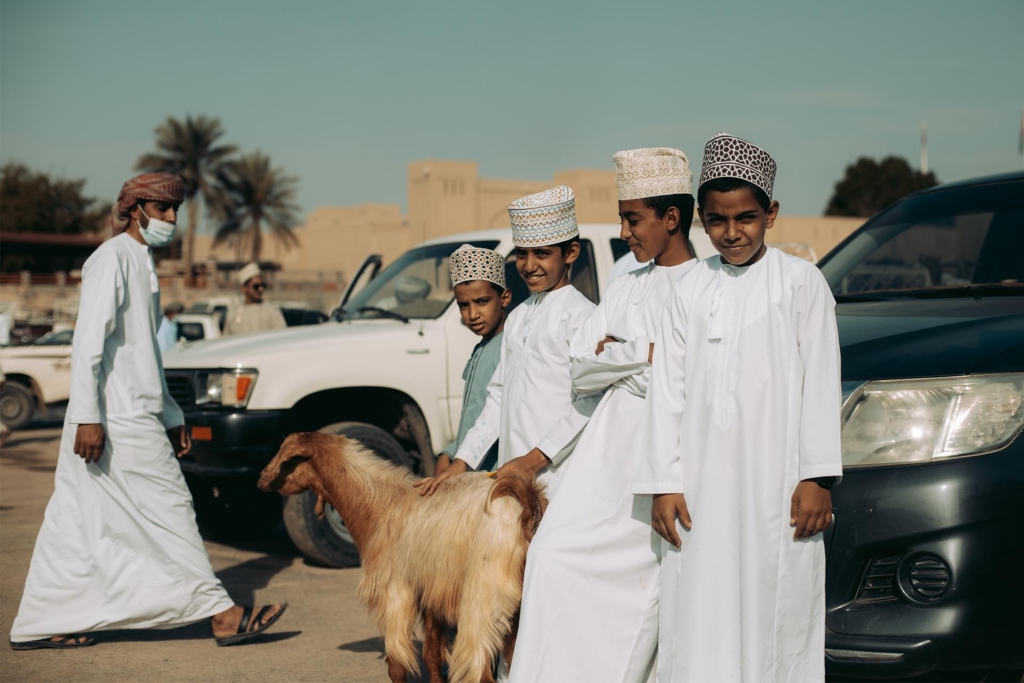 Z generace na generaci. Skupinka ománských kluků s kozou, přišli na aukci dobytka se svými otci.