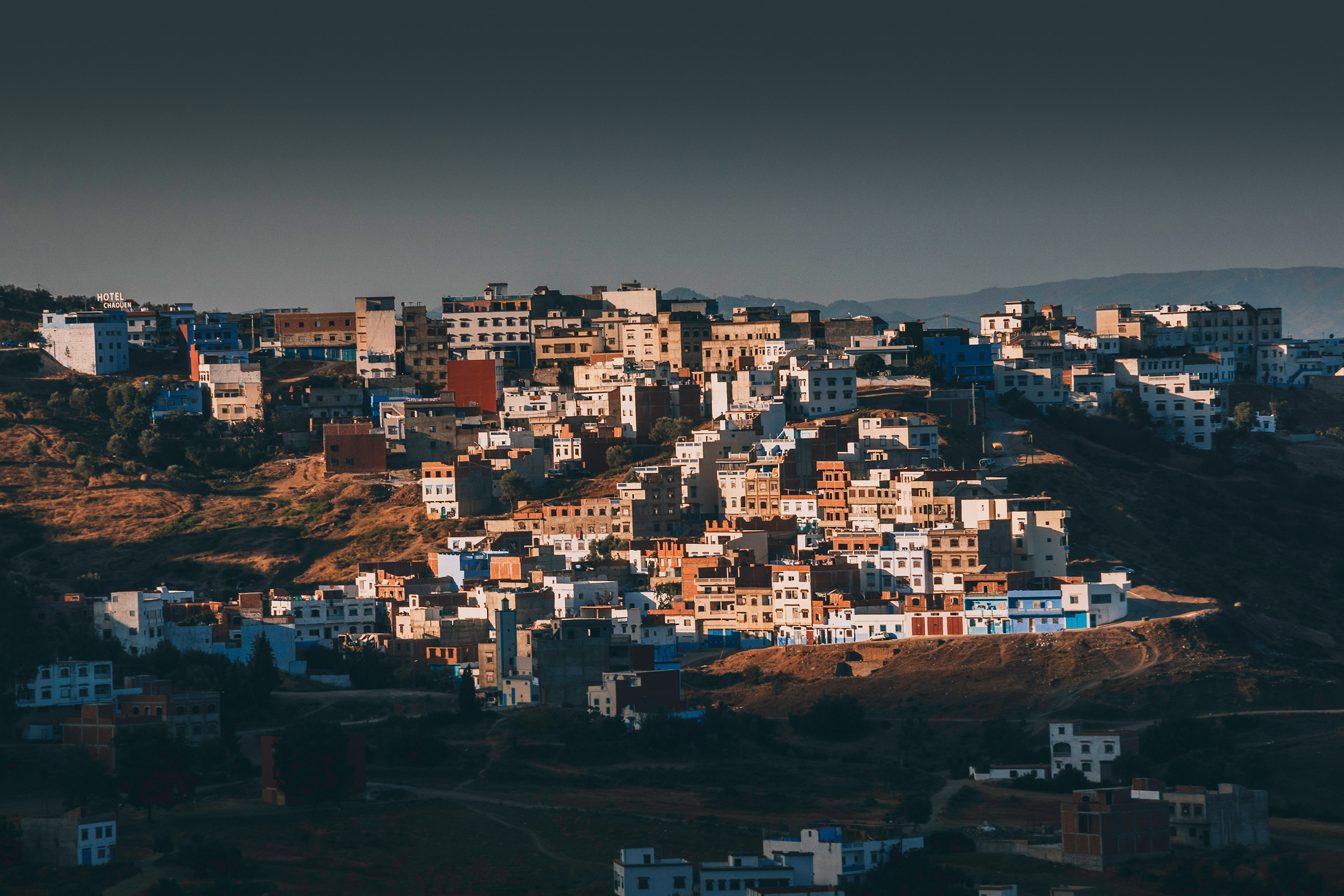 Výhled na domy posetý protilehlý kopec během východu slunce naproti severo africkému městu Chefchaouen.